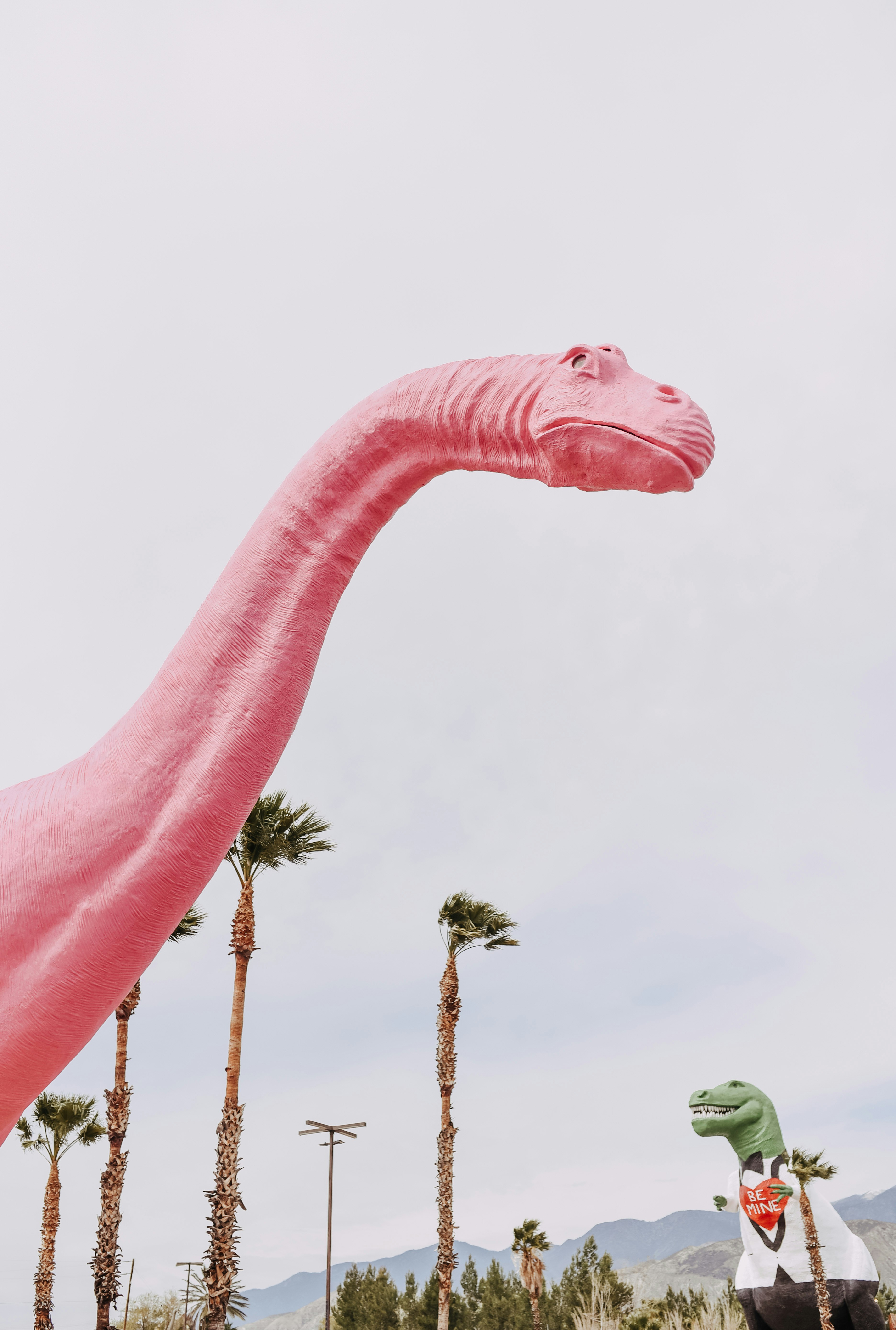 pink elephant statue near green trees during daytime